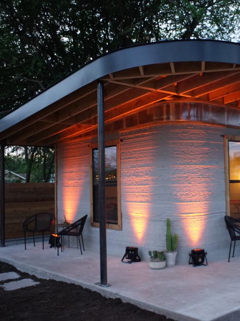 exterior of tiny concrete house with uplighting